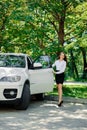 Beautiful girl opens the door of her car