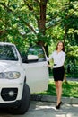 Beautiful girl opens the door of her car