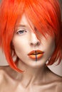 Beautiful girl in an orange wig cosplay style with bright creative lips. Art beauty image. Royalty Free Stock Photo