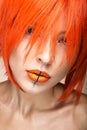 Beautiful girl in an orange wig cosplay style with bright creative lips. Art beauty image. Royalty Free Stock Photo