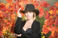 Beautiful girl outdoors in autumn fall. Young woman collects yellow fall leaves in autumn. Beauty woman holds autumn Royalty Free Stock Photo