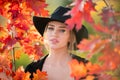 Beautiful girl outdoors in autumn fall. Young woman collects yellow fall leaves in autumn. Beauty woman holds autumn Royalty Free Stock Photo