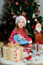 Beautiful girl in pajamas with blue skate is waiting Christmas and New year