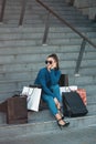 Beautiful girl with paper bags sits on a stairs outside shopping mall Royalty Free Stock Photo