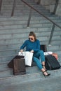 Beautiful girl with paper bags sits on a stairs outside shopping mall Royalty Free Stock Photo