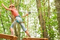 Beautiful girl in the park on the ropes achieve Outdoors