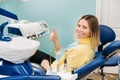 Beautiful girl patient shows the class with her hand while sitting in the Dentist`s chair Royalty Free Stock Photo