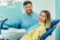 Beautiful girl patient shows the class with her hand while sitting in the Dentist`s chair Royalty Free Stock Photo