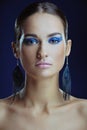 Beautiful girl with perfect skin in blue bright make-up in long earrings