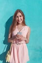 Beautiful girl in pink dress, happy smiles in her hands a telephone, in summer in city, fashionable and modern fashion Royalty Free Stock Photo