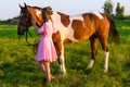 Beautiful girl in pink dress with horse in the field Royalty Free Stock Photo