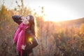 Beautiful girl with pink scarf at sunset in a field. Portrait at sunset, yellow light, beautiful background Royalty Free Stock Photo