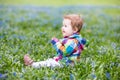 Beautiful girl playing among first blue flowers