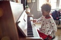 Beautiful girl is playing on piano x-mas music. Concept Christmas, New Year, holiday, family happiness, childhood Royalty Free Stock Photo