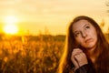 Beautiful girl in a posh red dress posing on a poppy field. Poppy field at sunset. Art processing. Sunset Royalty Free Stock Photo