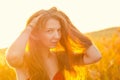 Beautiful girl in a posh red dress posing on a poppy field. Poppy field at sunset. Art processing. Sunset Royalty Free Stock Photo