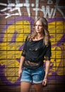 Young woman with black blouse and long hair against a graffiti wall Royalty Free Stock Photo