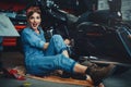 Beautiful girl posing repairs a motorcycle in a workshop, pin-up style, service and sale Royalty Free Stock Photo