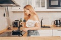 Beautiful girl prepares food on an induction stove. A woman prepares breakfast in a frying pan. The blonde in the bright kitchen