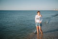 Beautiful girl with pretty legs walking along the seashore in the summer hot day near the sea Royalty Free Stock Photo