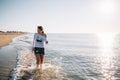 Beautiful girl with pretty legs walking along the seashore in the summer hot day near the sea Royalty Free Stock Photo