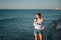 Beautiful girl with pretty legs walking along the seashore in the summer hot day near the sea Royalty Free Stock Photo