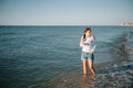 Beautiful girl with pretty legs walking along the seashore in the summer hot day near the sea Royalty Free Stock Photo