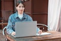 Beautiful girl prints on laptop and makes notes in notebook, concept online learning