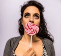 Beautiful girl with professional make-up with a colorful lollipop Royalty Free Stock Photo