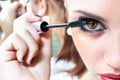 Beautiful girl putting makeup on her eyes Royalty Free Stock Photo