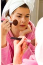 Beautiful girl putting on makeup in the mirror Royalty Free Stock Photo