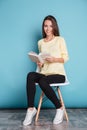 Beautiful girl reading book and sitting on chair Royalty Free Stock Photo