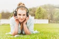 Beautiful girl reading in nature, smiling and listening music Royalty Free Stock Photo