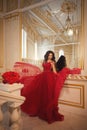 Beautiful girl in a red ball gown in palace interiors Royalty Free Stock Photo