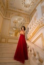 Beautiful girl in a red ball gown in palace interiors Royalty Free Stock Photo