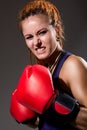 Beautiful girl with red boxing gloves, aggressive and looking at Royalty Free Stock Photo