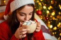 Cheerful girl enjoying comfortable Christmas atmosphere at home