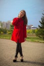 Beautiful girl in a red coat on a park alley Royalty Free Stock Photo