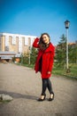 Beautiful girl in a red coat on a park alley Royalty Free Stock Photo