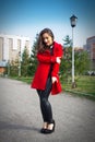Beautiful girl in a red coat on a park alley Royalty Free Stock Photo