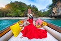 Beautiful girl in red dress on longtail boat at Koh Lao Lading island, Thailand