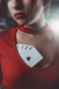 beautiful girl in red dress with a neckline in which poker cards. woman in poker games of chance excitement Royalty Free Stock Photo