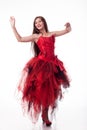 Beautiful girl in red dress posing on camera on white background.