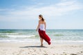 Beautiful girl in red dress by the sea.