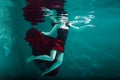 Beautiful girl in a red dress swims under water. amazing Underwater