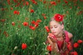 Beautiful girl in red dress walks at poppy field Royalty Free Stock Photo