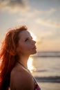Beautiful girl with red hair posing on the beach. Sunset. Royalty Free Stock Photo