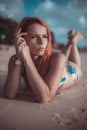 Beautiful girl with red hair posing on the beach. Sunset. Royalty Free Stock Photo