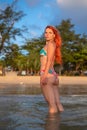 Beautiful girl with red hair posing on the beach. Sunset. Royalty Free Stock Photo