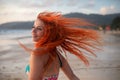 Beautiful girl with red hair posing on the beach. Sunset. Royalty Free Stock Photo